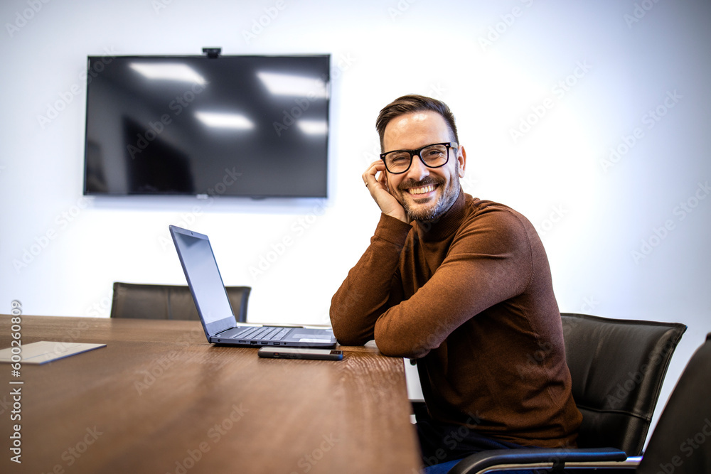 Portrait of smiling man in the office in front of his tablet computer. Portrait of smiling man in the office in front of his tablet computer.