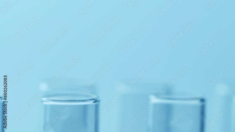 Laboratory test glass tubes shaking during earthquake, nobody. Closeup on blue background Laboratory test glass tubes shaking during earthquake, nobody. Closeup on blue background
