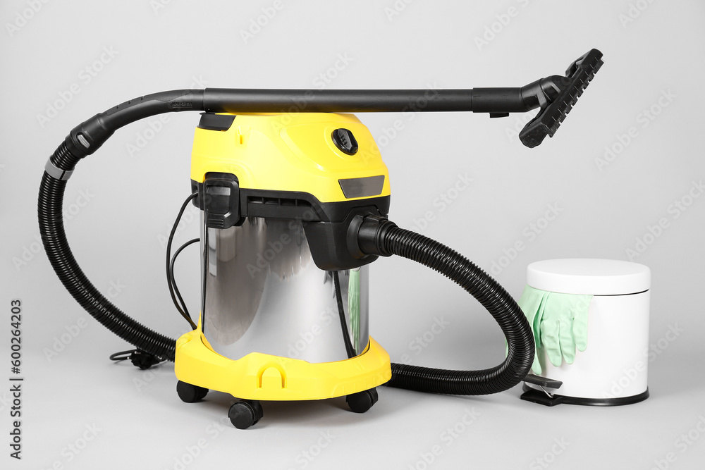 Vacuum cleaner with bin on grey background Vacuum cleaner with bin on grey background