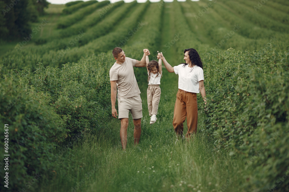 Family with little daughter spending time together in sunny field Family with little daughter spending time together in sunny field