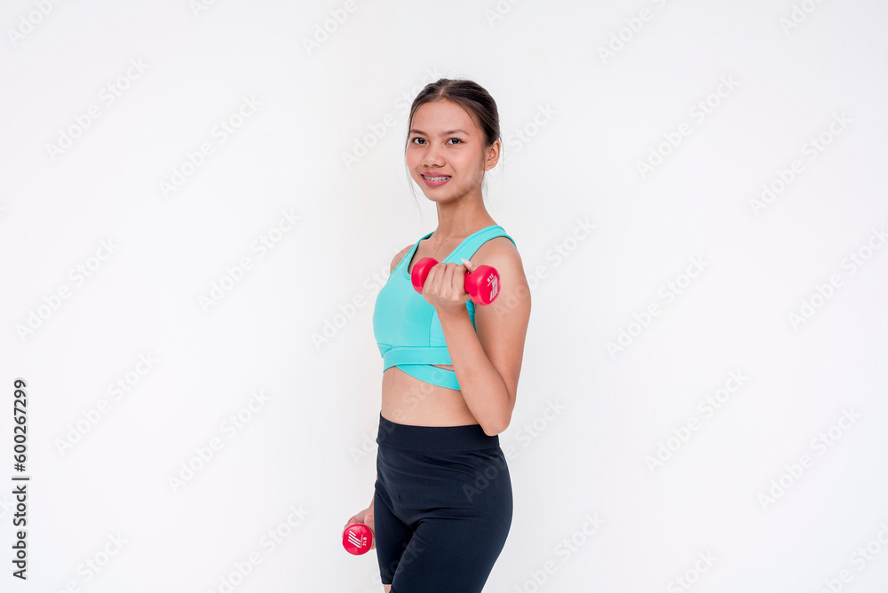 A healthy and joyful woman weightlifting and working out using a dumbbell, side view. Isolated on a white background. A healthy and joyful woman weightlifting and working out using a dumbbell, side view. Isolated on a white background.