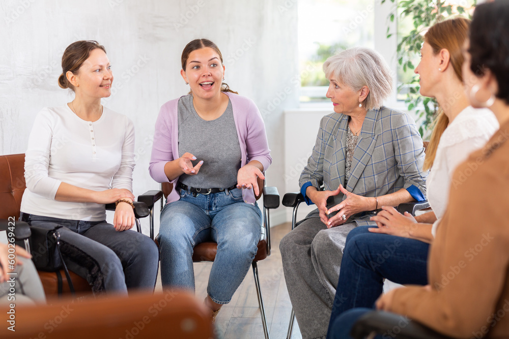 Fototapeta premium Young female teacher giving lecture to group of students in classroom