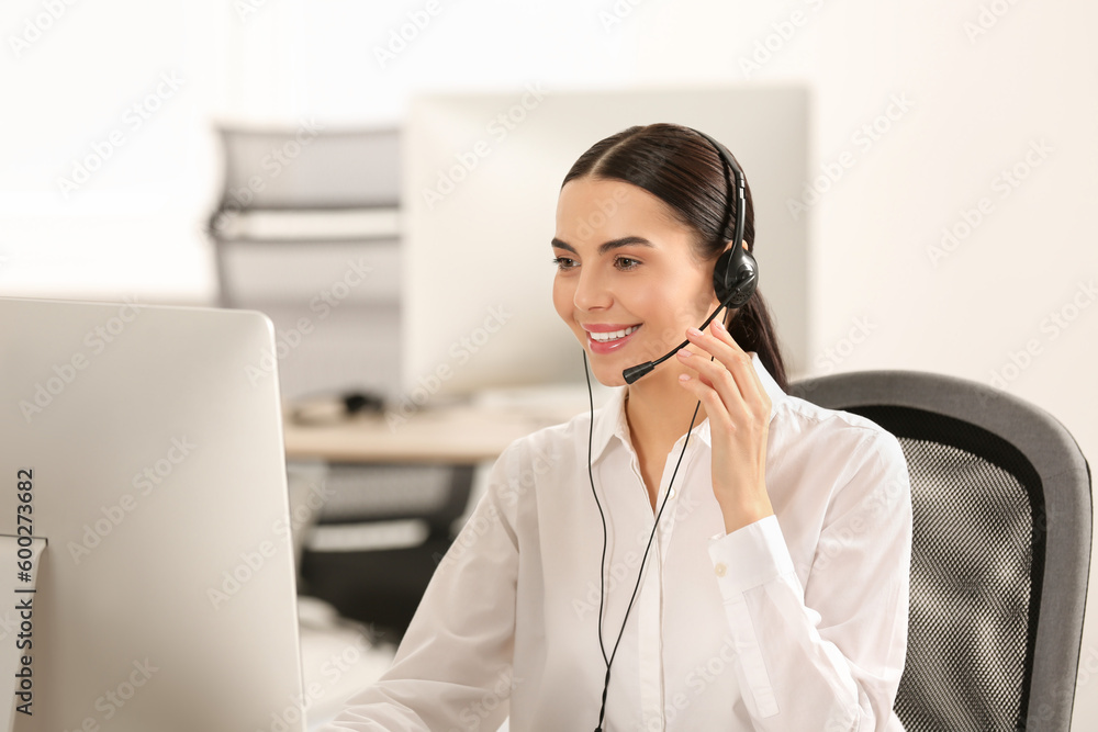 Hotline operator with headset working on computer in office Hotline operator with headset working on computer in office