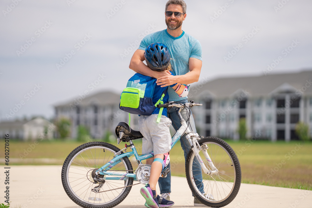 Little kid learning to ride bicycle with father in park. Father teaching son cycling. Father and son learning to ride a bicycle at Fathers day. Father support and helping son. Child care. Little kid learning to ride bicycle with father in park. Father teaching son cycling. Father and son learning to ride a bicycle at Fathers day. Father support and helping son. Child care.