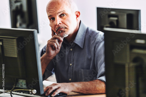 man at computer listens to you skeptically photo