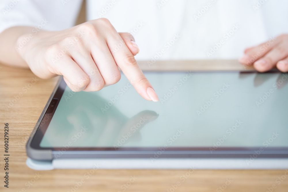 タブレットPCの画面を触って操作する女性の手元 タブレットPCの画面を触って操作する女性の手元