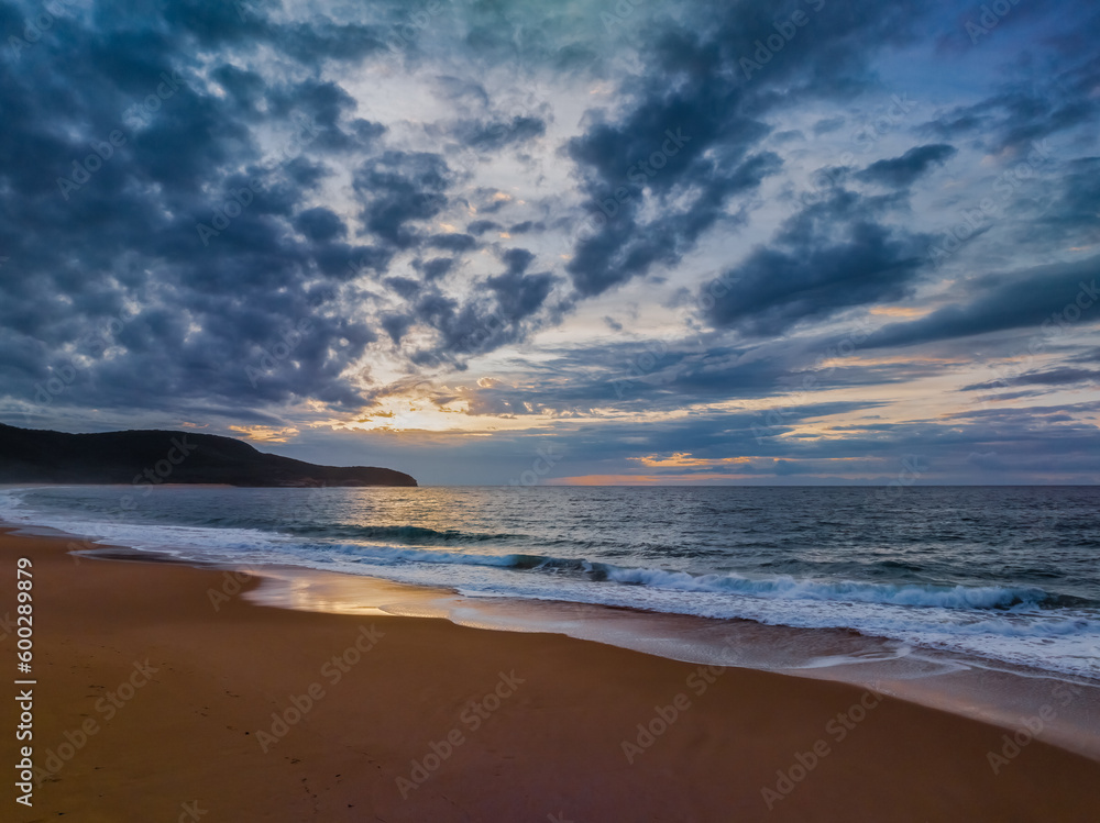 Sunrise seascape with clouds and gentle surf