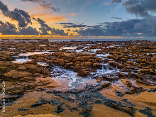 Sunrise and clouds over the ocean and rock platform