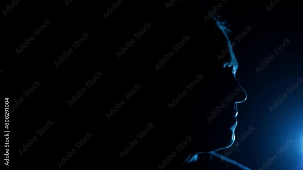 Cinematic shot of a female sitting on a chair with a light on half of his face, dramatic light. HD footage. Cinematic shot of a female sitting on a chair with a light on half of his face, dramatic light. HD footage.