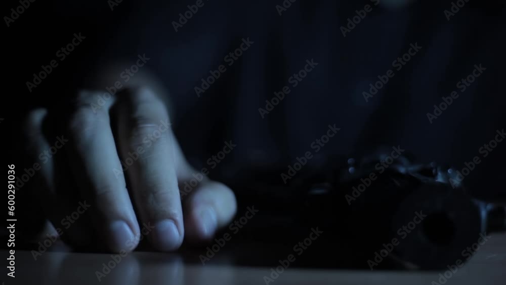 Close-up shot of a man picking up a gun from a table, creative light cinematic shot HD footage.
Close-up shot of a man picking up a gun from a table, creative light cinematic shot HD footage.