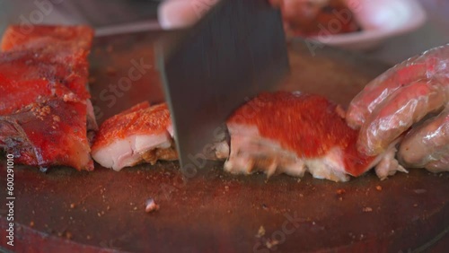 Chefs are cutting up charcoal-grilled roast pigs at a Chinese food stall