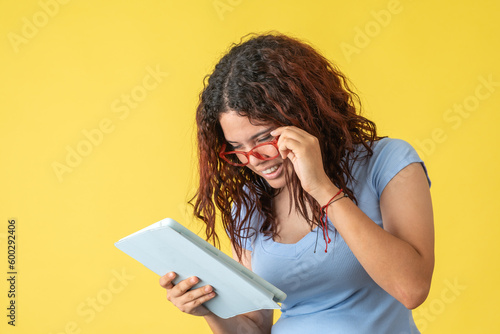 Woman with glasses reading on tablet