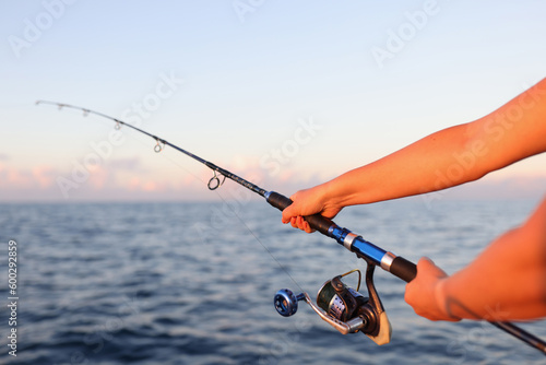 фотографія Woman sitting holding fish rod in hands