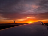 Gorgeous sunset view with orange, pink, purple sky as the plane lands at Washington Dulles and passes the control tower