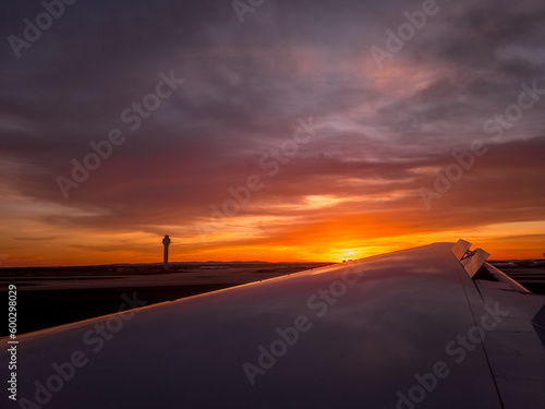 Gorgeous sunset view with orange, pink, purple sky as the plane lands at Washington Dulles and passes the control tower