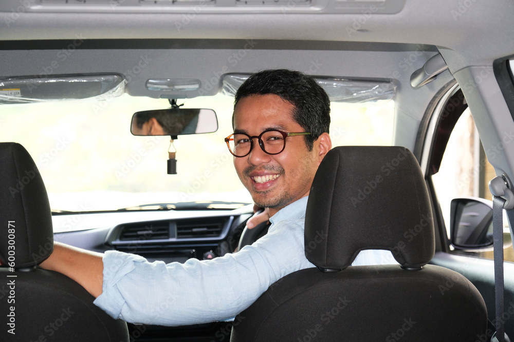 A car driver looking behind to passenger with happy expression A car driver looking behind to passenger with happy expression