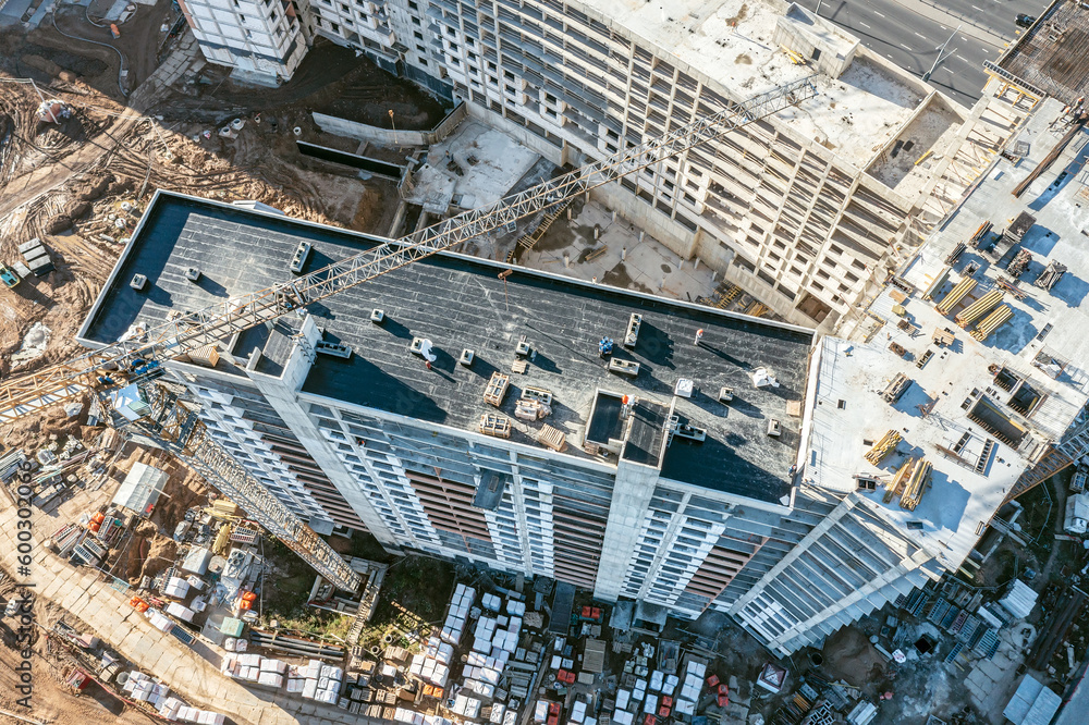 crane working on under construction high-rise residential building. aerial drone photo looking down.
