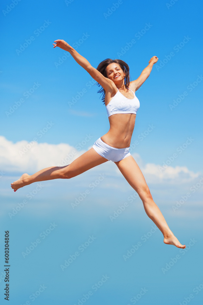 Freedom, portrait and body of woman jump in underwear on blue sky background with energy, happy or mockup. Smile, jumping and girl model in air in celebration, health or achievement and summer fun