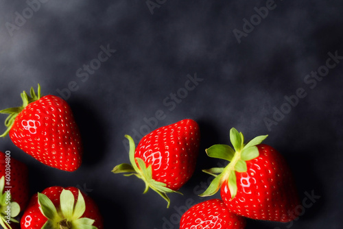 Ripe strawberries on a dark table, top view. AI generation