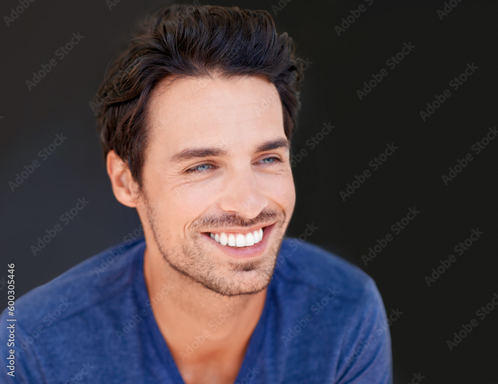 Obraz premium Face, smile and handsome man or happy male with white teeth or oral hygiene and isolated on a dark, black background. Motivated, cheerful and attractive guy or dental health or beauty in studio