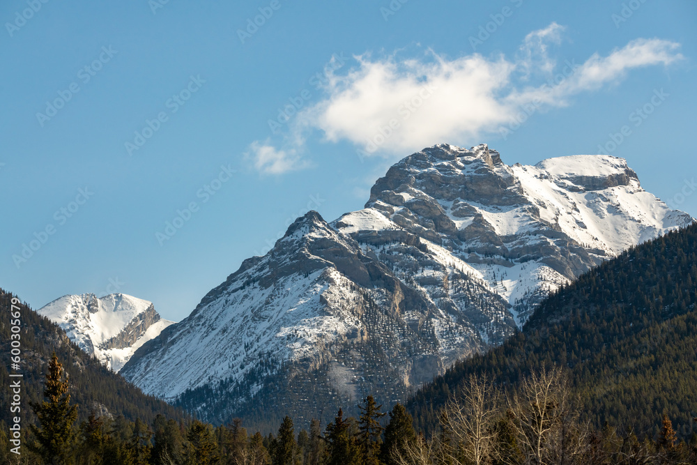 Magnificent scenery along the highway to Banff National Park in spring time with blue sky behind cascading snow capped mountains above.	