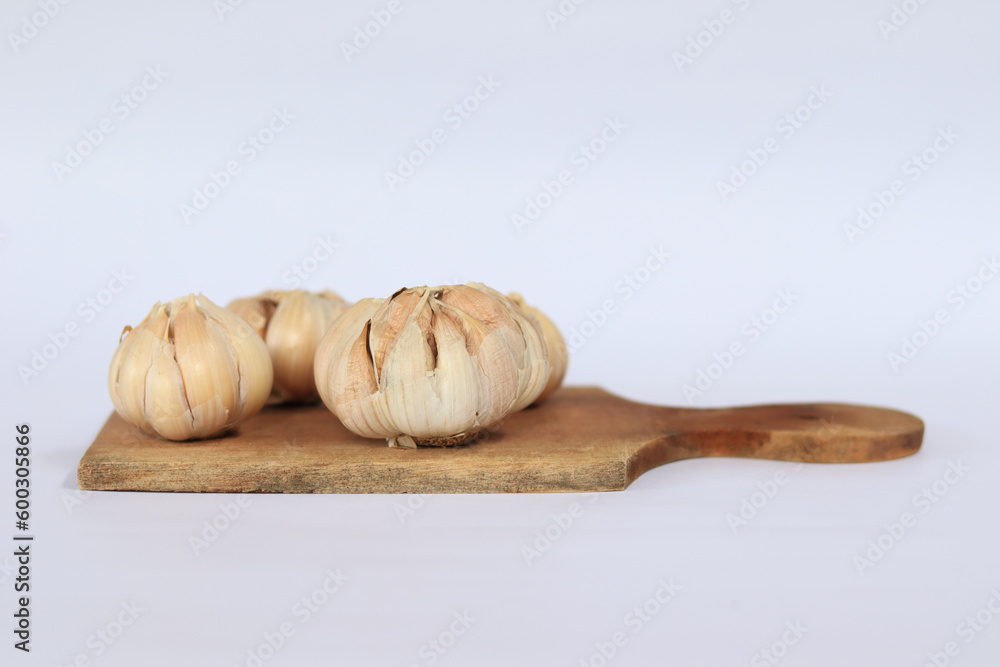 Fresh garlic on a cutting board on a white background Fresh garlic on a cutting board on a white background