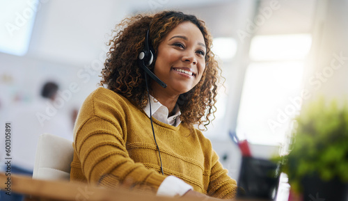 Happy african woman, call center agent or listen on voip headset for consulting, communication or contact. Girl, customer service or tech support crm with smile, headphones or microphone at help desk photo