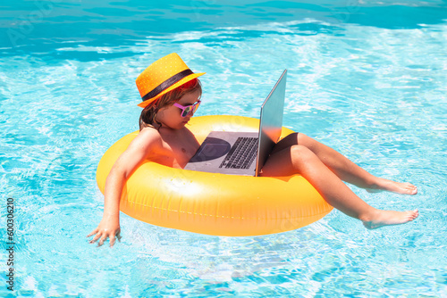 Freelance work concept. Child with laptop in swimming pool in summer day. Business travel.