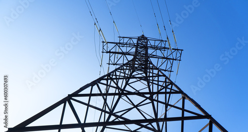 Power line. High-voltage power transmission tower with wires. High voltage line. Energy industry. Energy transfer over blue sky. Energy industry. Power substation..