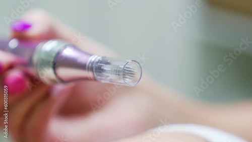 Dermapen with microneedles used for facial treatments. Close up. photo