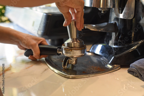 Hands pressing coffee beans for a coffee machine close up