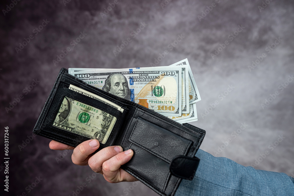 Businessman hand holding cash dollar in wallet Businessman hand holding cash dollar in wallet