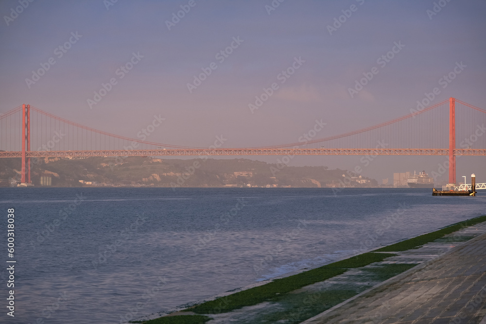 Fototapeta premium Luxury ocean liner cruiseship cruise ship Victoria or Elizabeth in port of Lisbon, Portugal during Mediterranean cruising with city skyline, Christos statue and suspension bridge