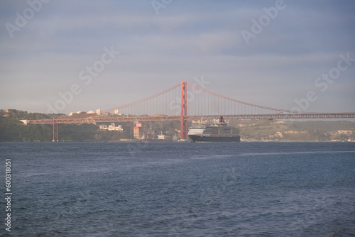 Luxury ocean liner cruiseship cruise ship Victoria or Elizabeth in port of Lisbon, Portugal during Mediterranean cruising with city skyline, Christos statue and suspension bridge