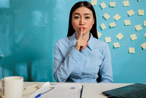 Slika na platnu Professional woman making the gesture of silence with finger over mouth, keeping a confidential secret