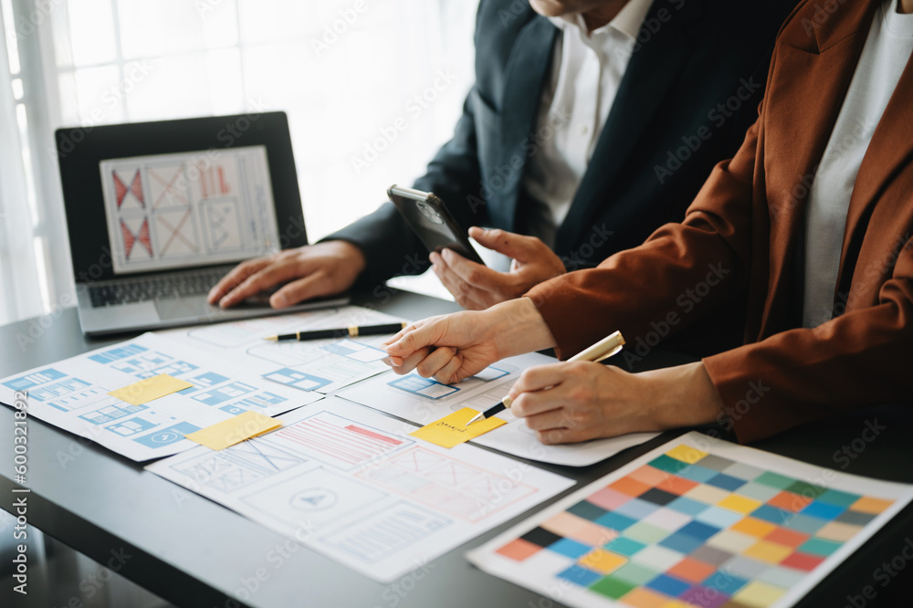 UX developer and ui designer brainstorming about mobile app interface wireframe design with customer breif and color code at office.. UX developer and ui designer brainstorming about mobile app interface wireframe design with customer breif and color code at office..