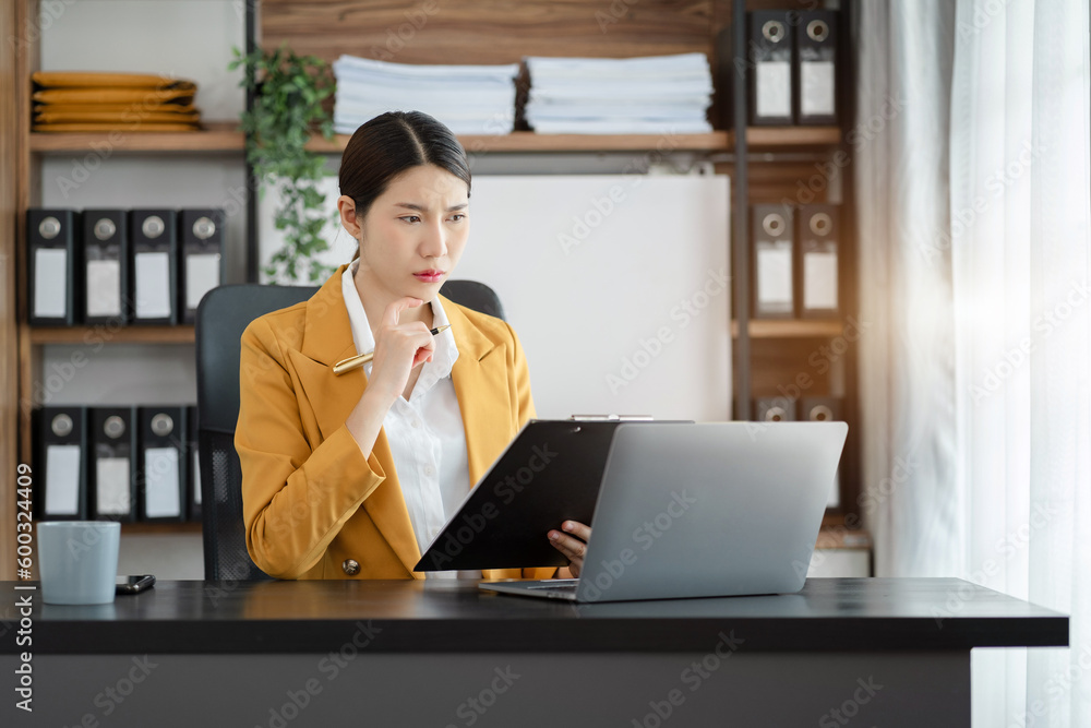 Asian business woman working at office with laptop and documents on his desk, financial adviser analyzing data. Asian business woman working at office with laptop and documents on his desk, financial adviser analyzing data.