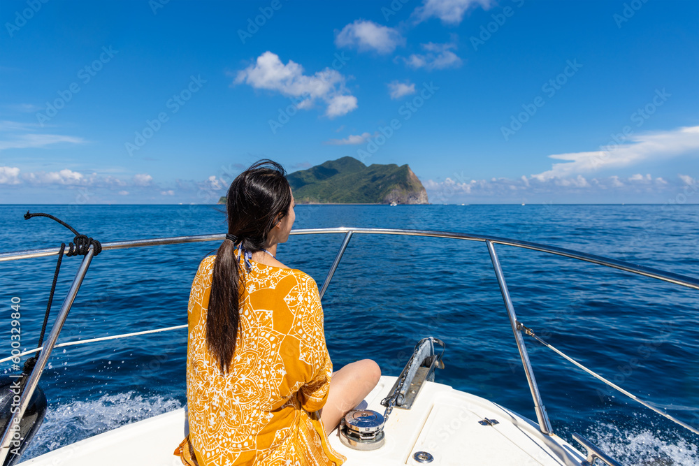 Young woman sitting on the front of a sail boat