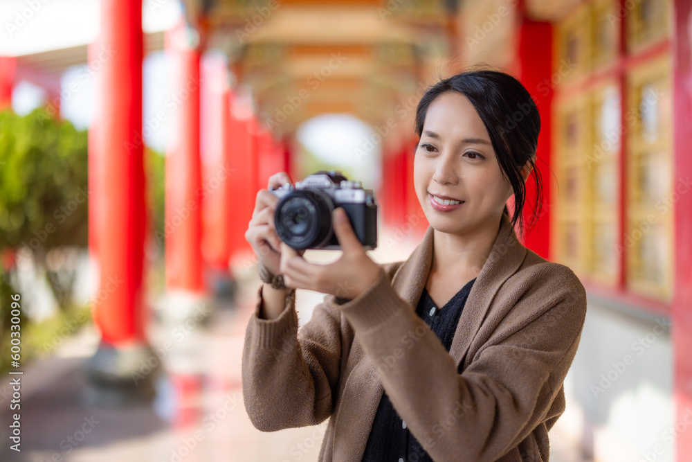 Travel woman use digital camera to take photo in Chinese temple