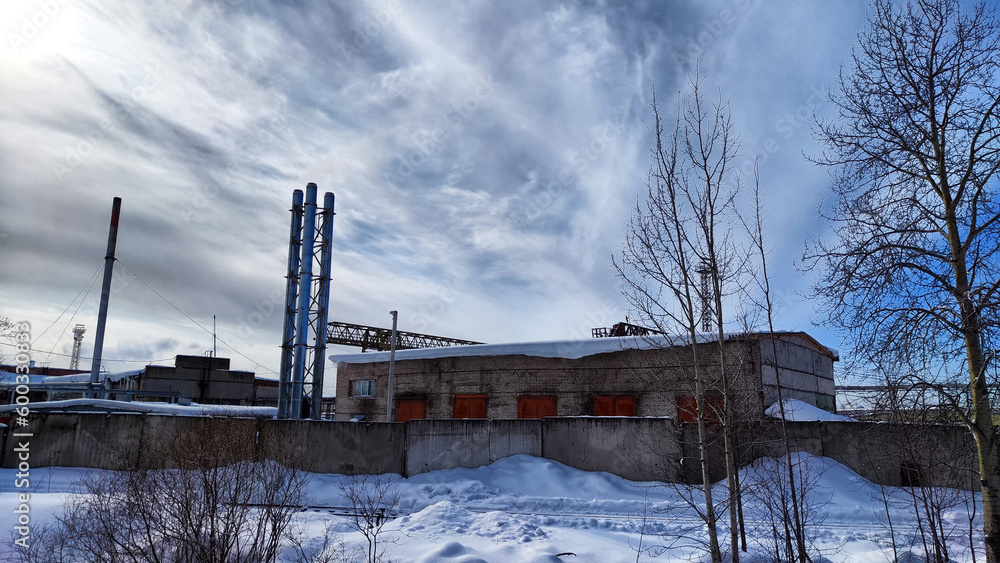 Abandoned Industrial Buildings in winter day and sky with white clouds on Background