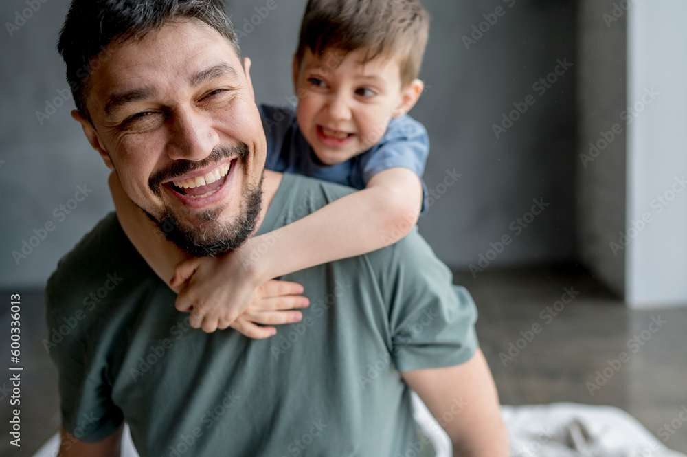 Cheerful man playing with son at home Cheerful man playing with son at home