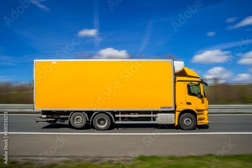 Germany, North Rhine Westphalia, Yellow truck driving along A 46 photo