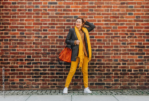Wallpaper Mural Stylish woman with scarf and jacket standing in front of brick wall Torontodigital.ca