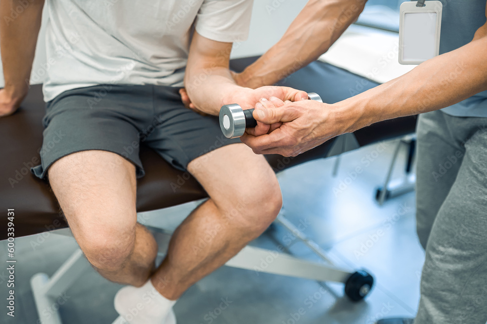 Male patient sitting on a couch and exercising his arm