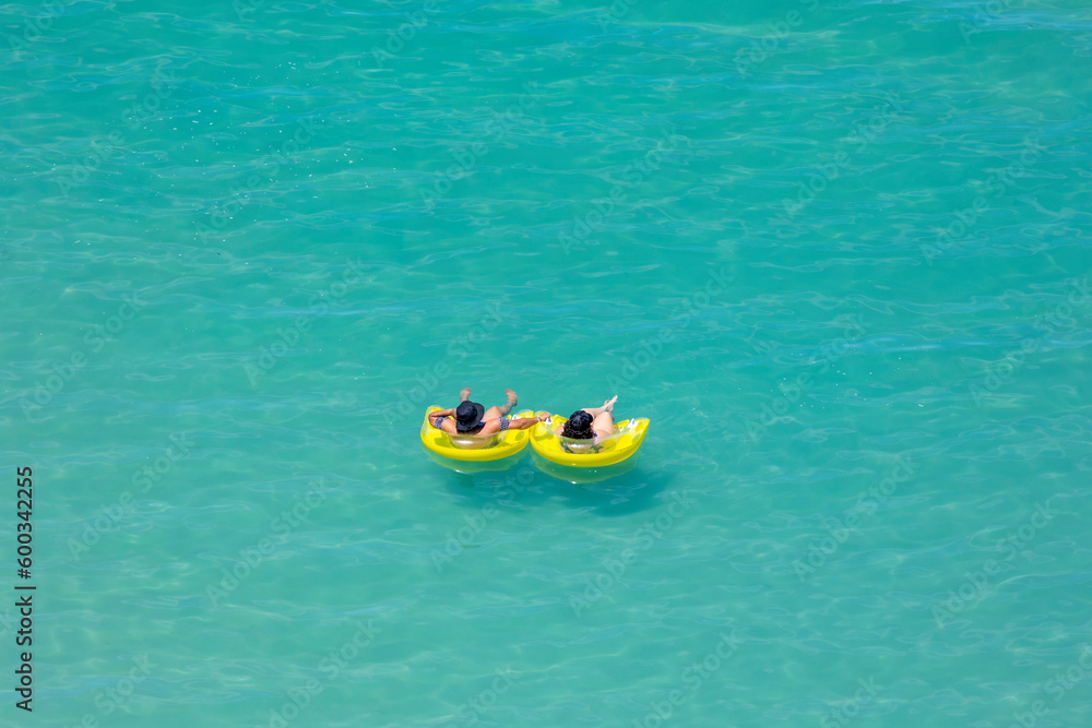 Couple Floating on Inner Tubes in the Ocean at the Beach