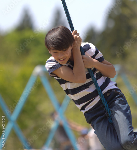 a young boy swinging on a rope