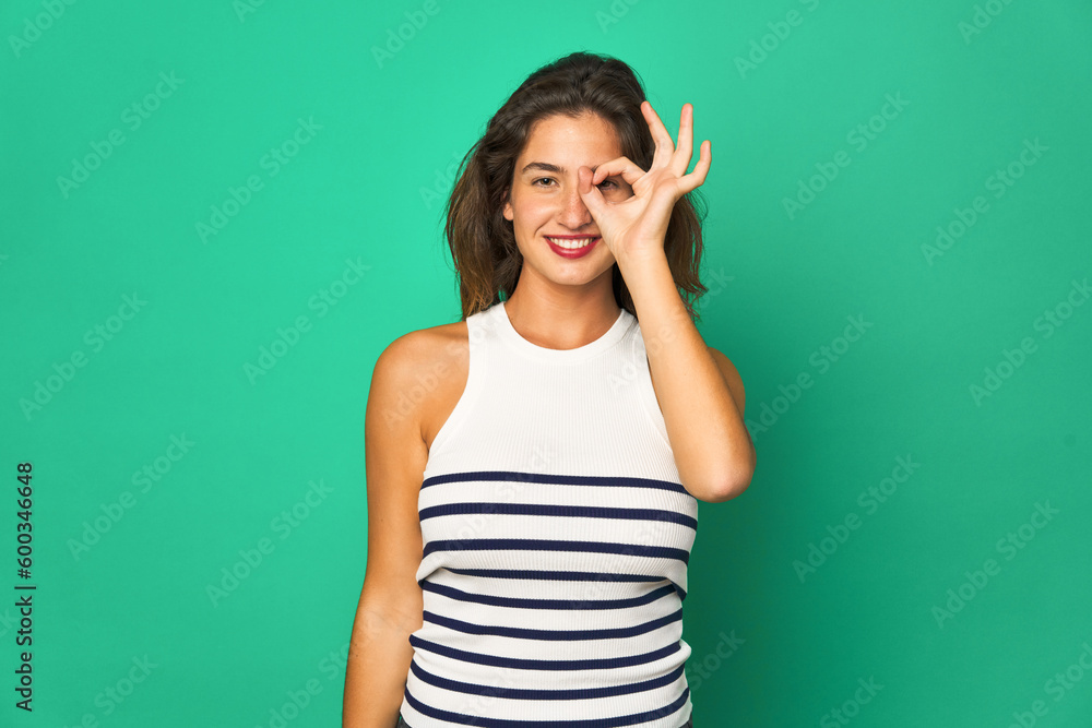 Young caucasian woman isolated excited keeping ok gesture on eye. Young caucasian woman isolated excited keeping ok gesture on eye.