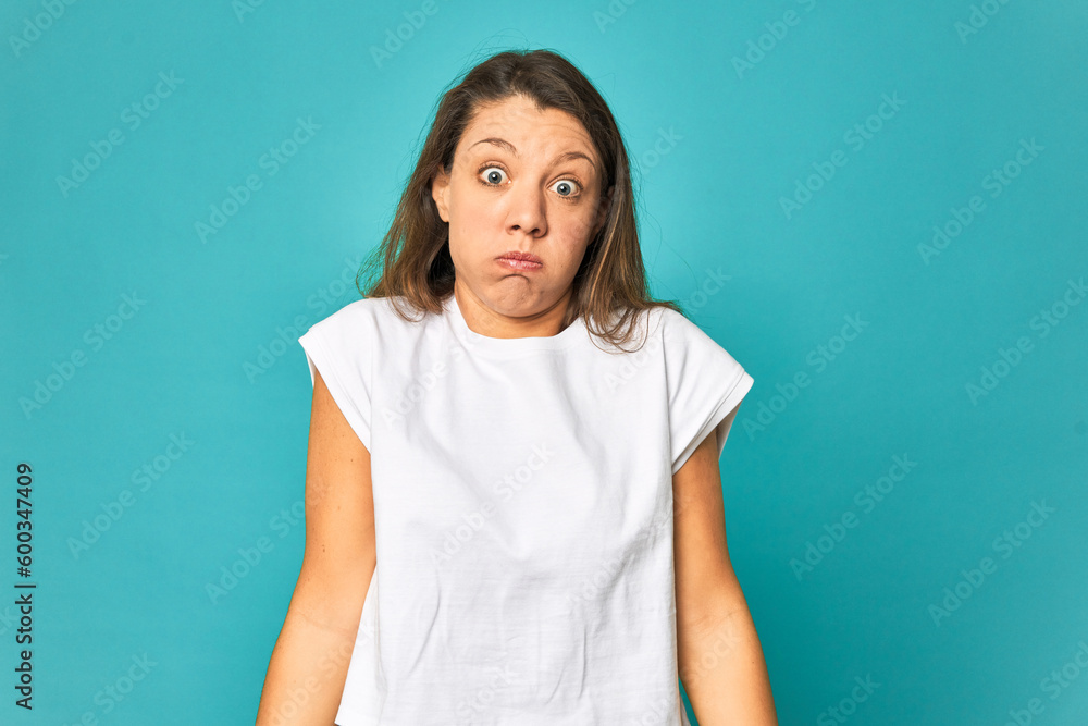 Fototapeta premium A young caucasian woman isolated shrugs shoulders and open eyes confused.