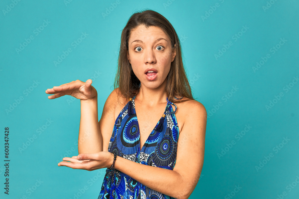 A young caucasian woman isolated shocked and amazed holding a copy space between hands. A young caucasian woman isolated shocked and amazed holding a copy space between hands.