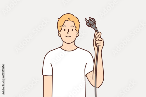 Man shows wire with plug from electrical equipment, offering to turn off appliances for save energy
